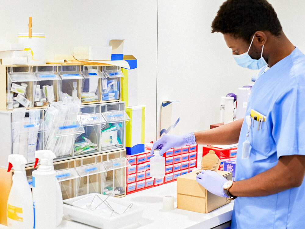 A nurse at a workstation of medical equipment.