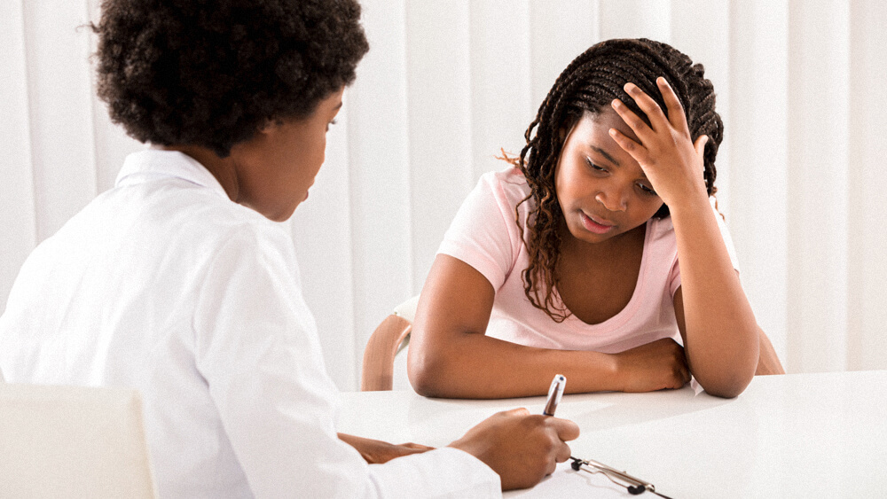 A psychiatric mental health nurse interviews a young patient.