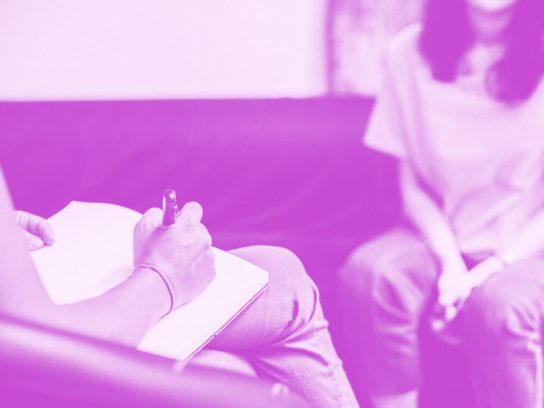 Psychologist client sitting on a sofa talking during a counseling session.