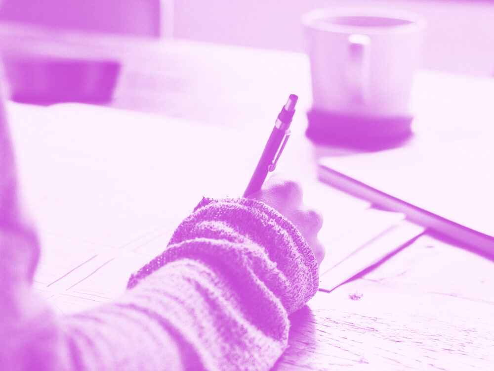 Social worker takes notes while sitting at a desk.