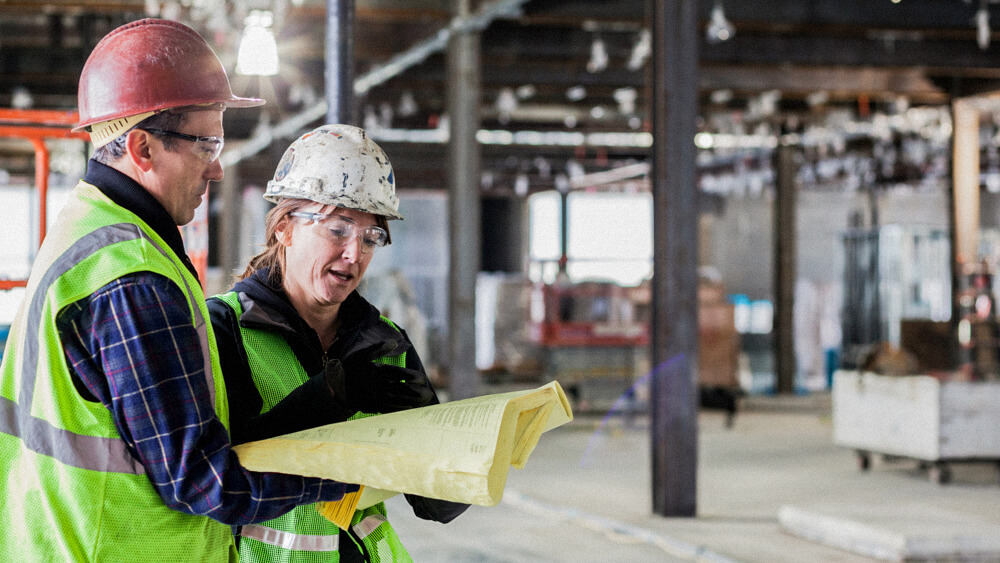 An employee works on a laptop in a warehouse.