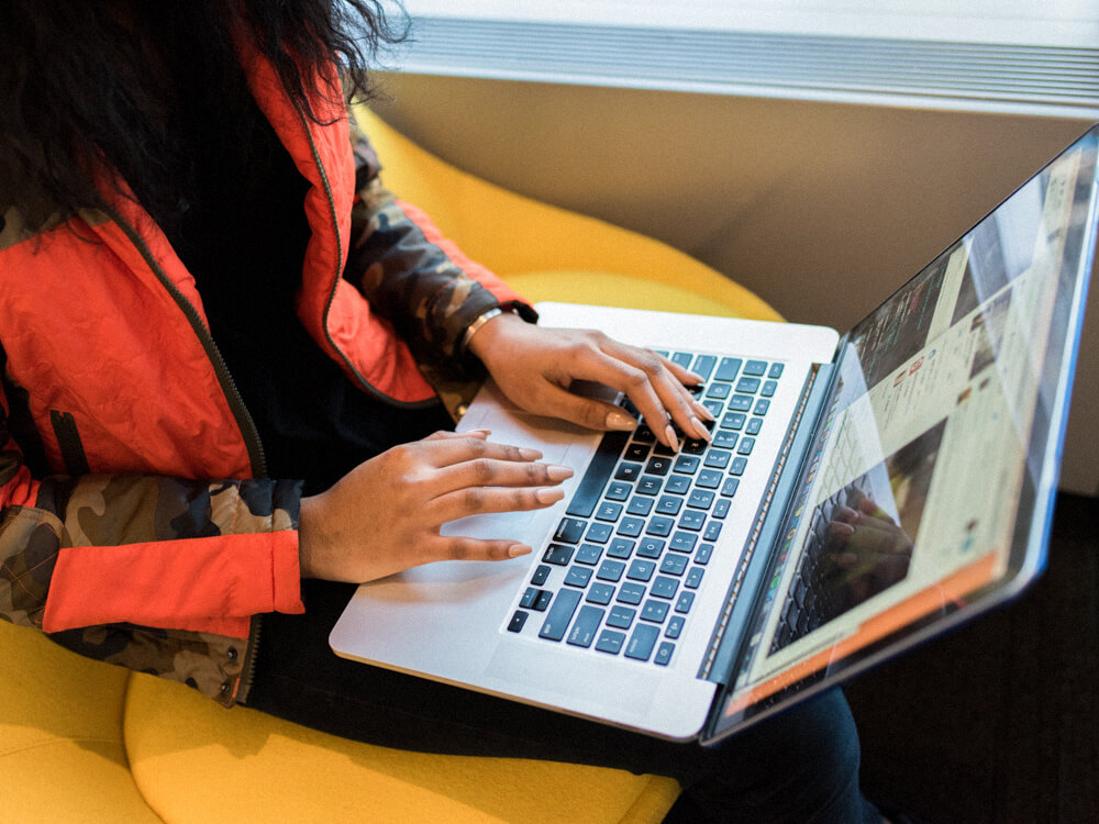 Computer technician works from laptop while commuting.