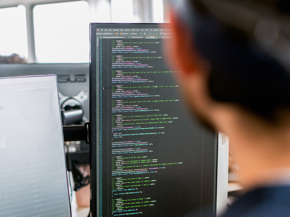 Vertical orientated monitor seen over shoulder of cybersecurity analyst.