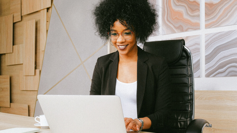 Financial investment advisor works in a trendy office on a laptop.