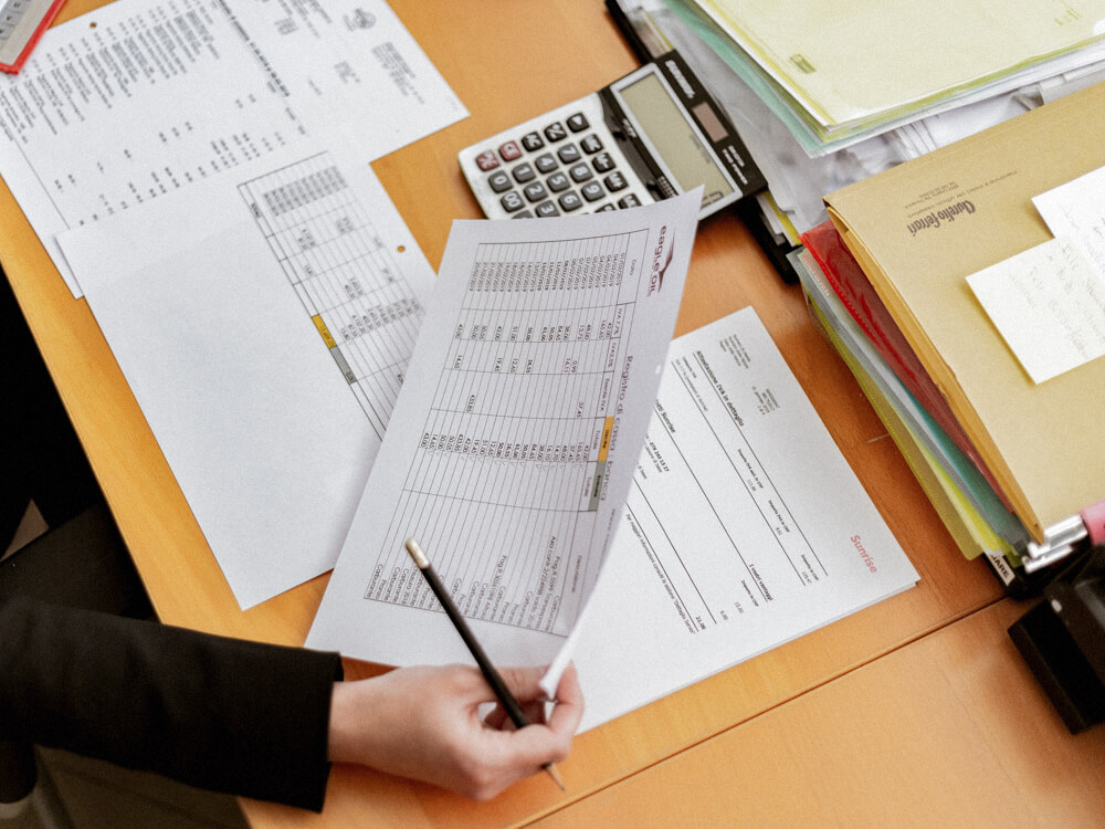 Financial general securities representative reviews printed documents on their desk.