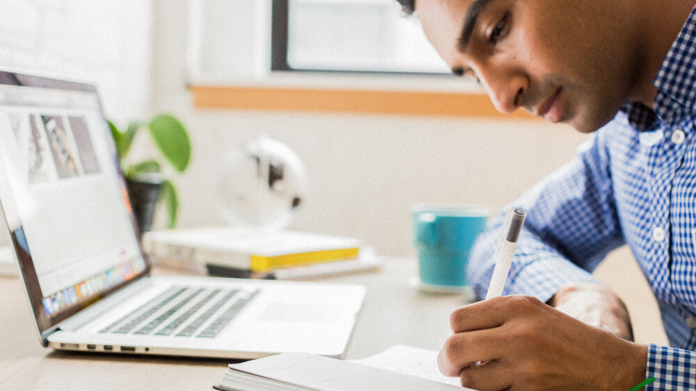 Financial general securities representative takes notes at their desk.