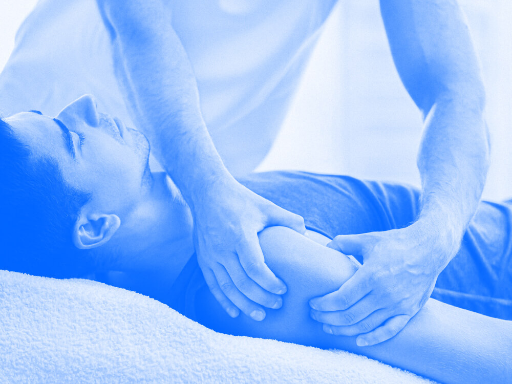 A massage therapist works on the shoulder of a client.