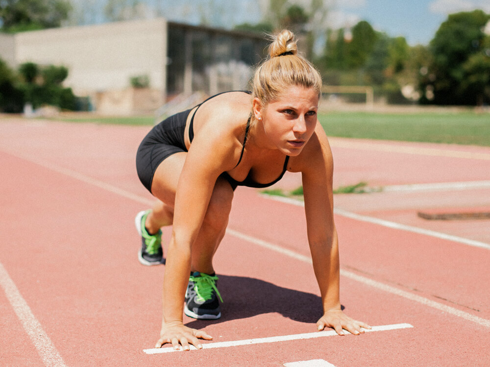  A sprinter on track in a lunge set position.