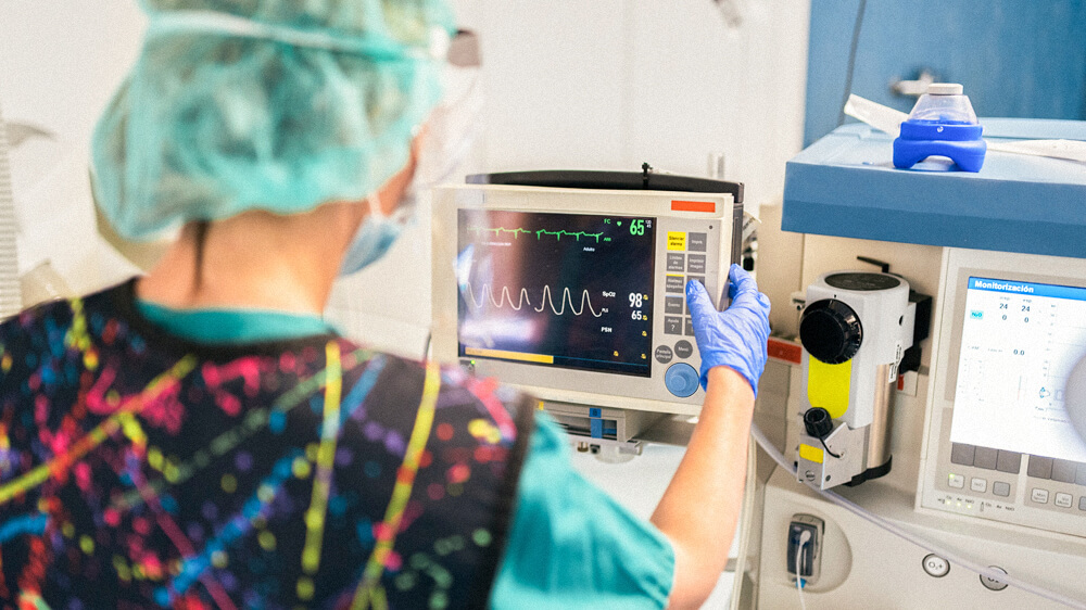 A technician reads an EKG from a medical device.