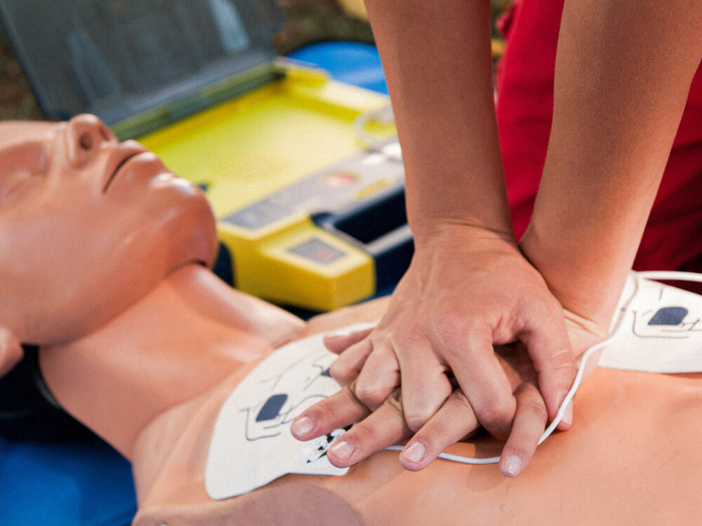 A student practicing CPR on a dummy.