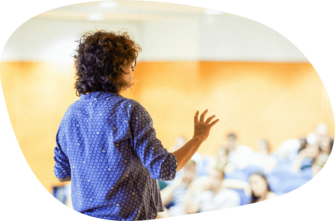 An instructor teaches to a room of students in a college setting.