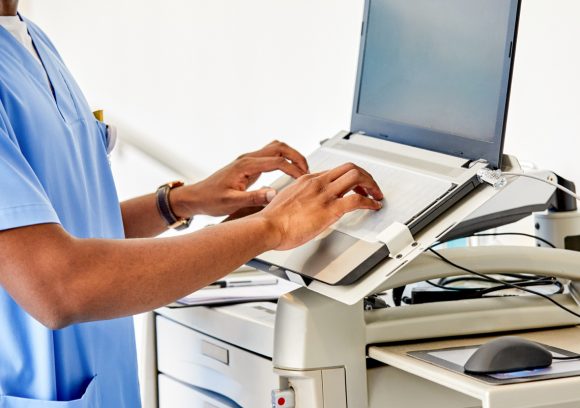 A certified professional coder works on a computer in a hospital setting.