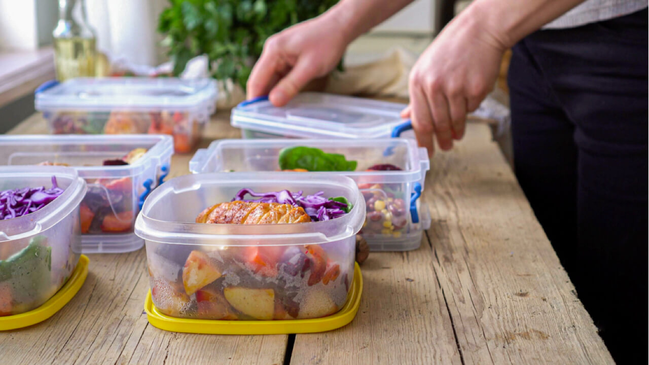 Dietitian preparing multiple healthy meals in Tupperware.