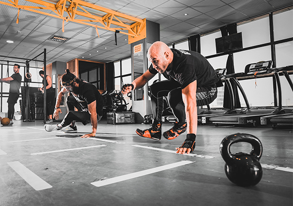 Two tactical personnel engaged in tactical training at a gym.