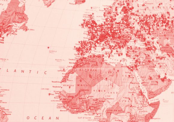 A map of Europe and Africa with lots of pushpins in various locations. Red-toned close up.