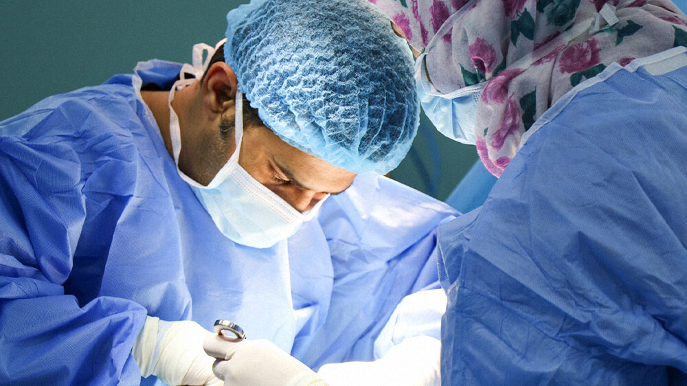 Man in surgeon attire conducting procedure