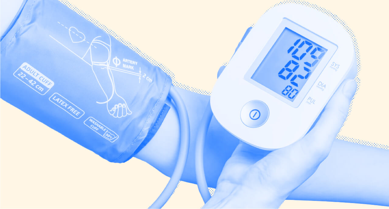 A person wears a blood pressure cuff while a nurse monitors it. Close up.