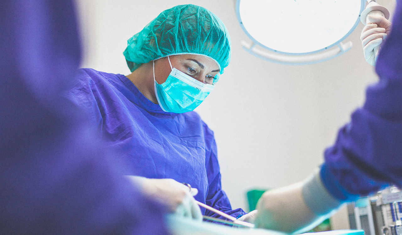 Perioperative nurse working on a patient in an OR.