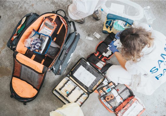 Emergency Medical Responder going through a medical kit. Overhead view.