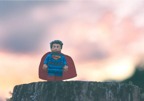 Miniature Superman figurine silhouetted against a sunset.