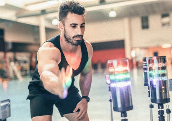 A person tests their speed and reflexes using light beacons in an athletic facility.