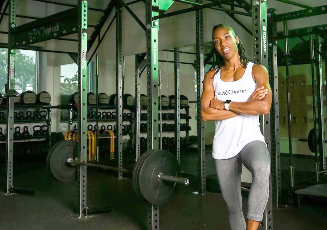 Chan Little - owner of The 360 Approach gym stands in front of a weight rack in her space.