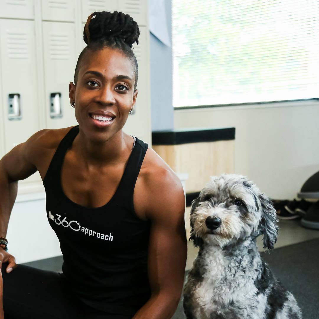 Chan Little - owner of The 360 Approach gym poses with her dog Thor on the floor.