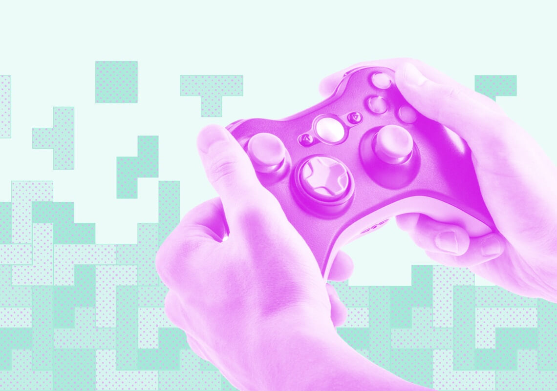 Close up of a person holding a pink-tinted video controller on a green background.
