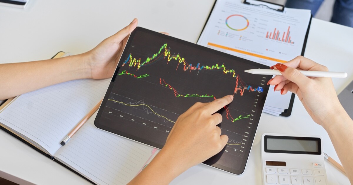 A financial analyst reviewing investment graphs on an iPad. Close up.