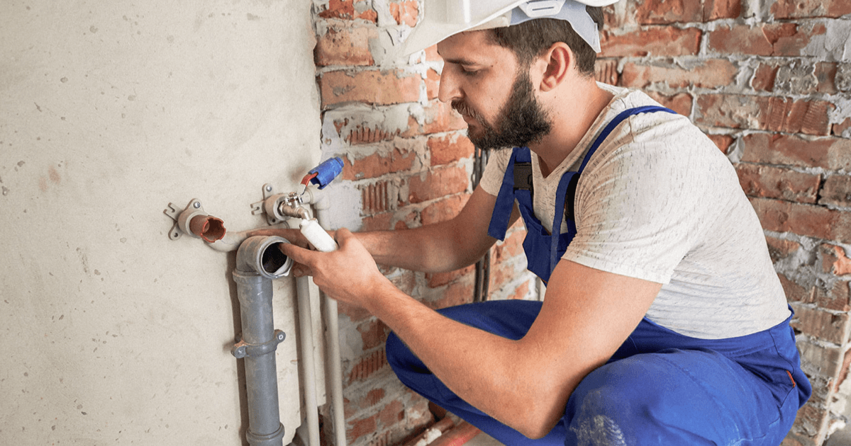 A residential plumber working on pipe fittings.