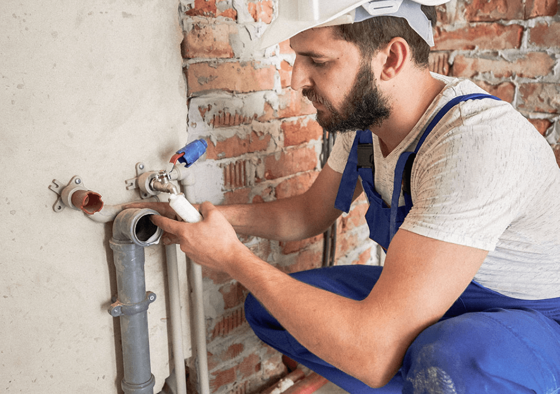A residential plumber working on pipe fittings.