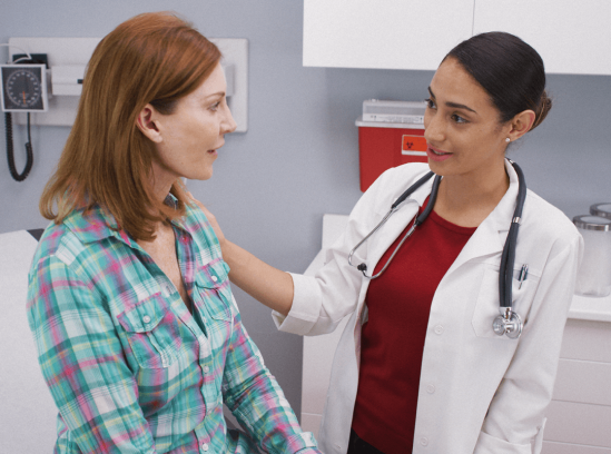 A family nurse practitioner speaks reassuringly to a patient during a consultation
